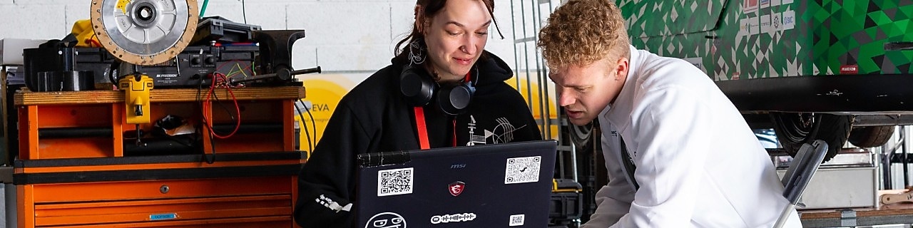 a woman and a man looking at something on a computer