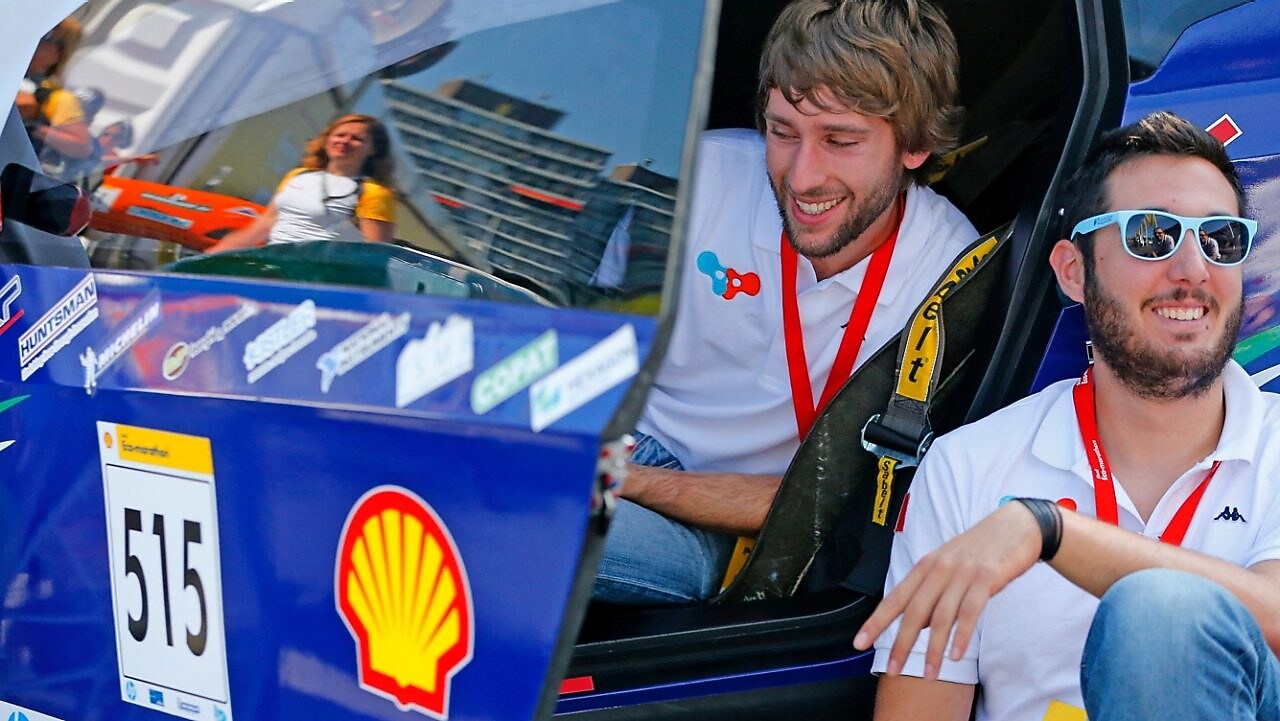 Students sitting by car