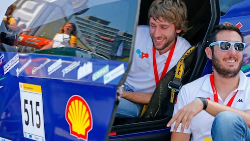 Students sitting by car