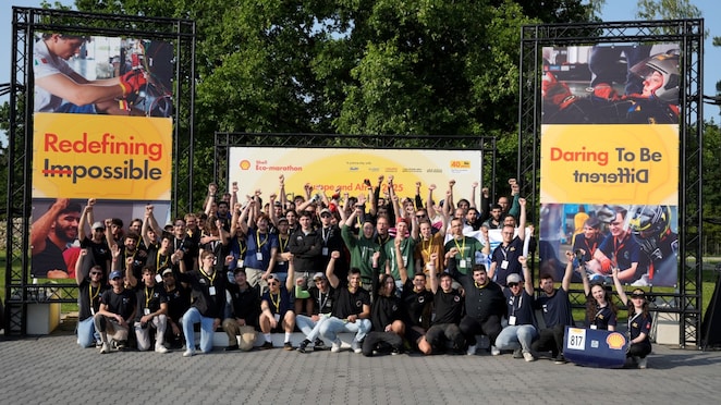 Autonomous Urban Concept team students posing on stage at Silesia Ring, Poland for Shell Eco-marathon Europe and Africa 2025