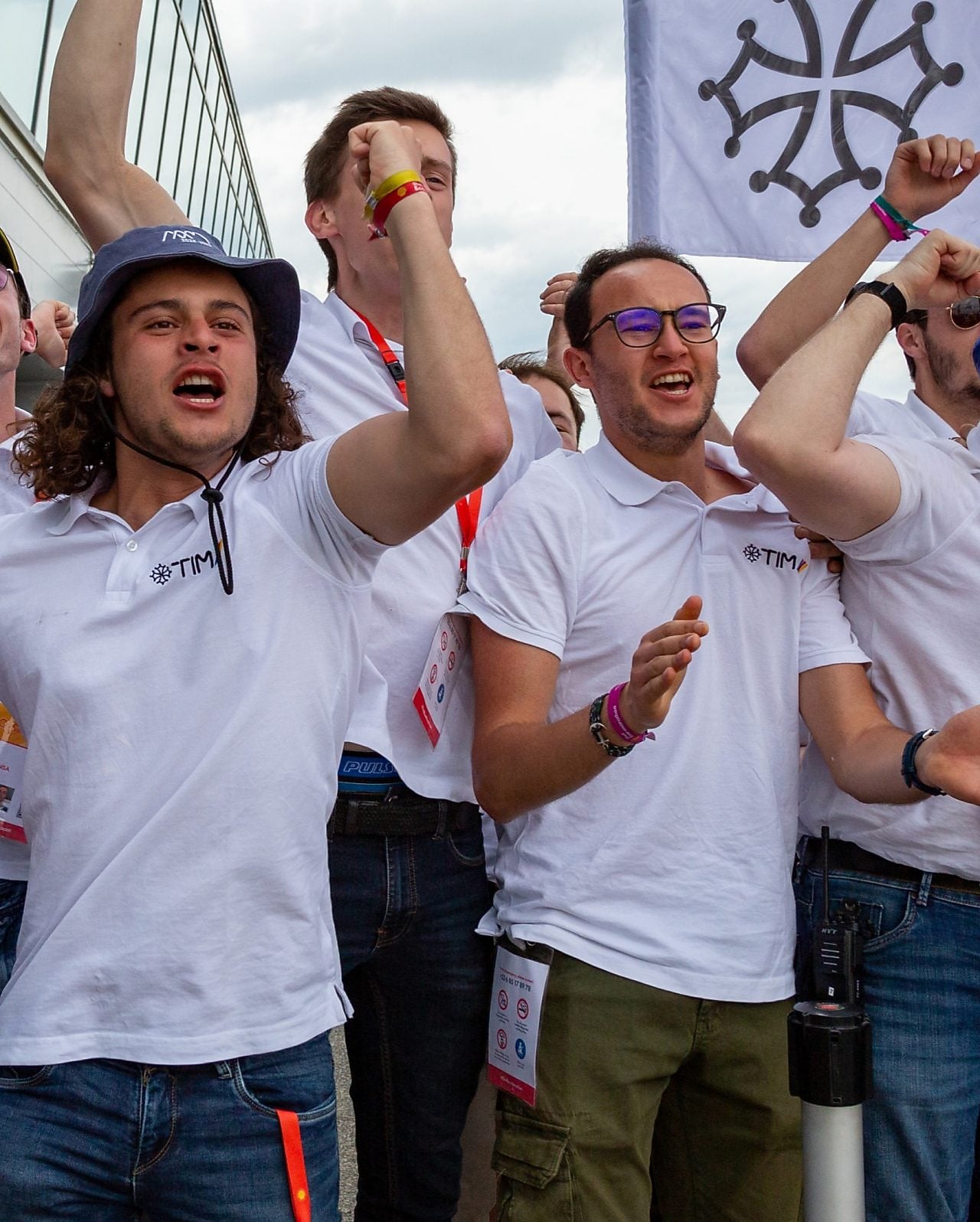 A group of people cheering in celebration in front of a building