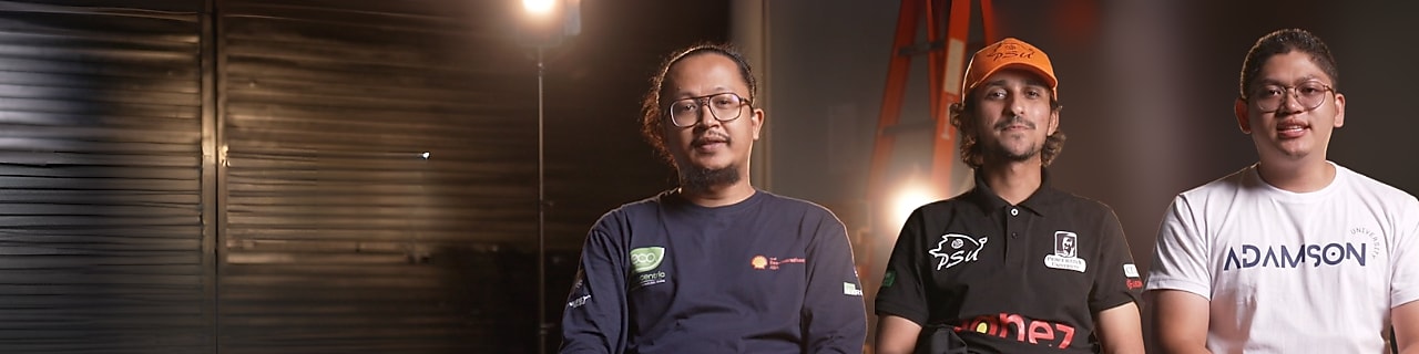Three young adults, sitting in a track paddock, speaking straight at the camera.