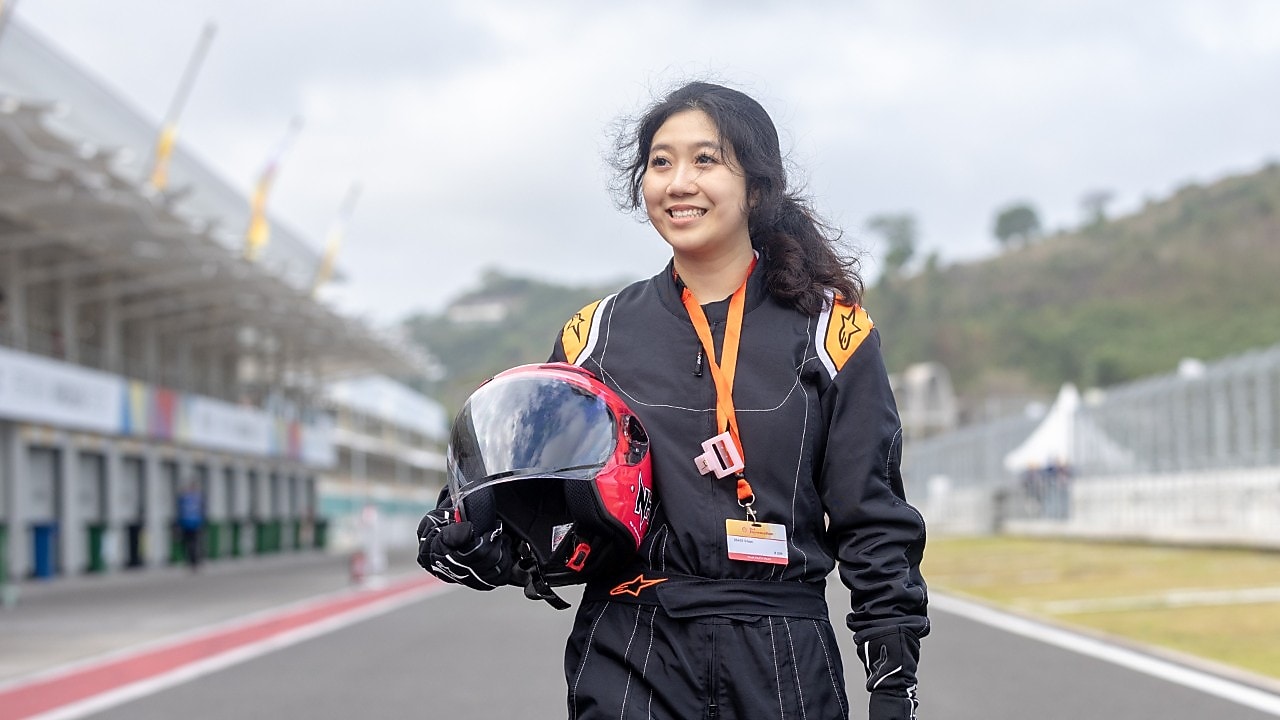 A person holding a helmet, smiling