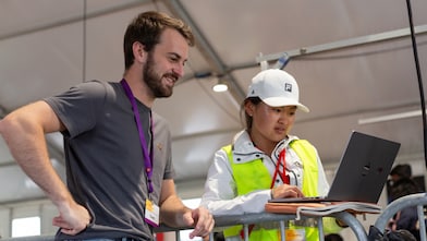 Two persons looking at a laptop