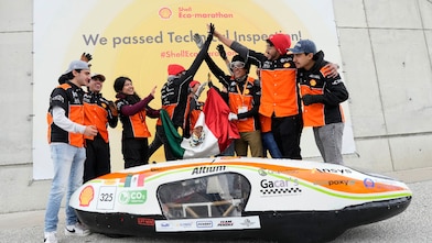 A group of young people cheering and high-fiving in celebration.