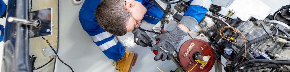  A young person working on an engine, view from the top.