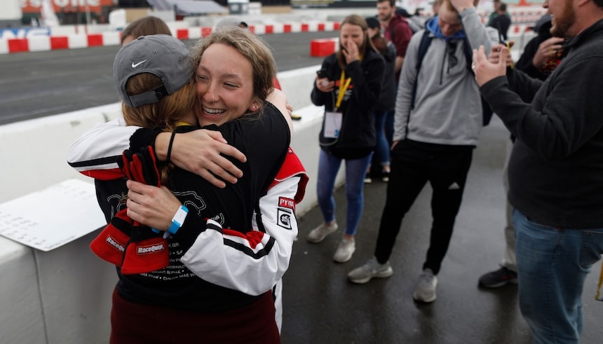 Two team mates celebrate on the side of the track