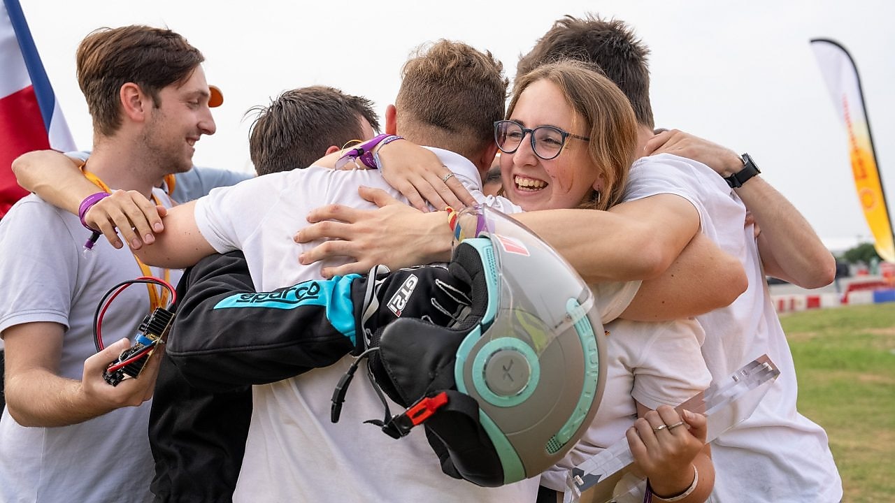 A group of students smiling, hugging and celebrating