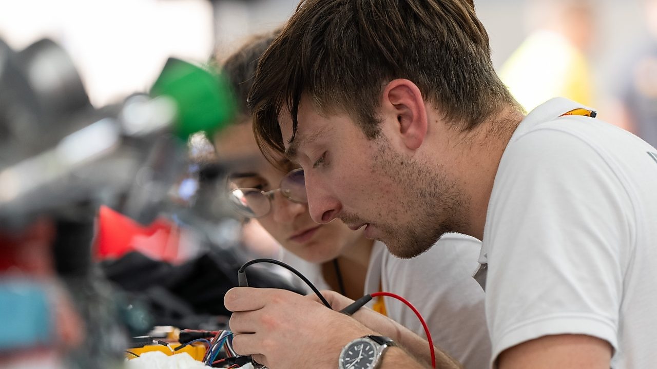 Two people working on a device