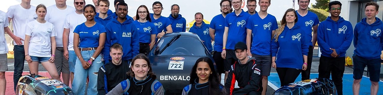People posing in front of futuristic prototype vehicles